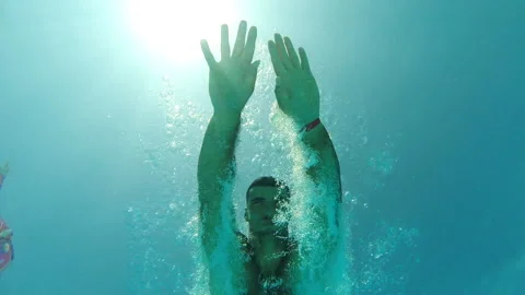 Young man diving into water. Guy refreshing in basin during resting on resort Stock Footage 297742244