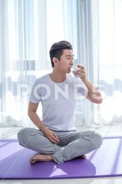 Young man do yoga in room drink water Stock-Fotos