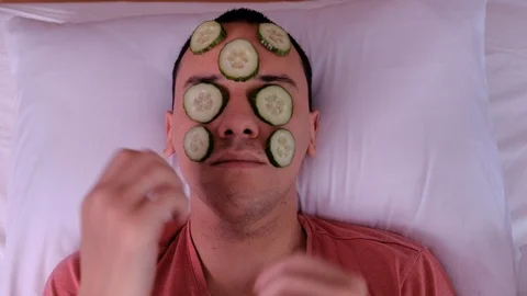 A young man does cosmetic procedures. 4k, cucumber mask Stock Footage 123499733