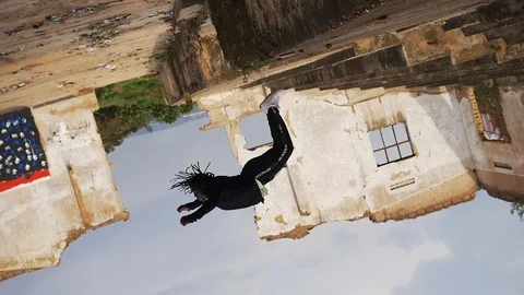 Young man does flips in the warehouse Stock Footage 117612266