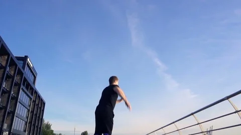 Young man does round house high kicks barefooted against sunrise in slow motion Stock Footage 77727663