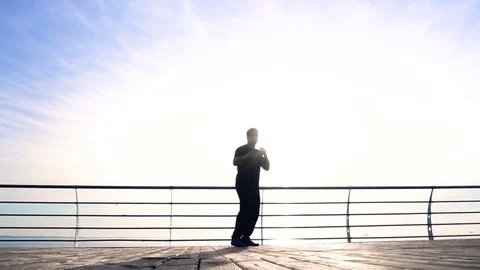 Young man does round house high kicks barefooted against sunrise in slow motion Stock Footage 78113666