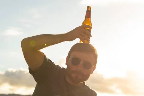 A young man does silly things while drinking beer Stock Photos