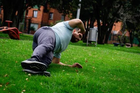 Young man doing abdominal exercise in a park in the city Stock Photos