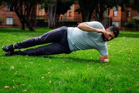Young man doing abdominal exercise in a park in the city Stock Photos