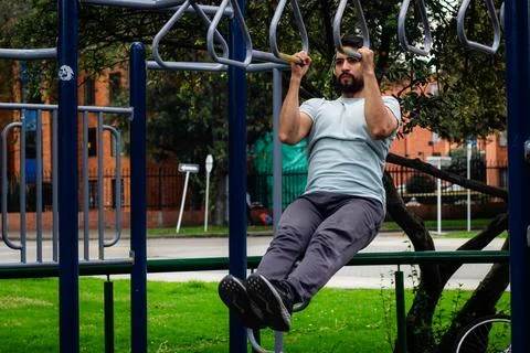 Young man doing arm exercise in a park in the city Stock Photos