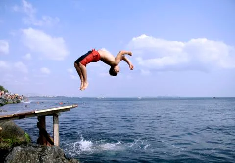 Young man doing a back flip into sea, istanbul, turkey Stock Photos