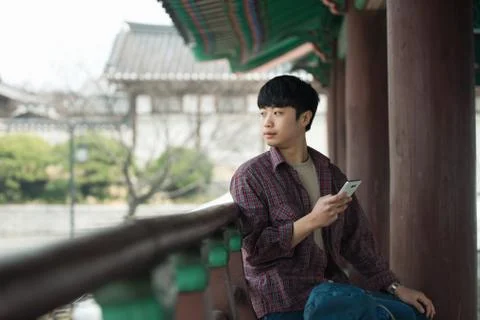 A young man doing a backpacking trip in a Korean traditional house. Use your  Stock Photos