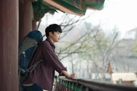 A young man doing a backpacking trip in a Korean traditional house. Stock Photos