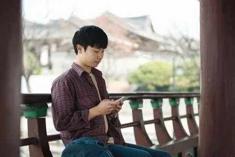 A young man doing a backpacking trip in a Korean traditional house. Use your  Stock Photos