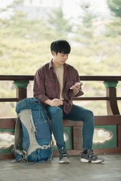 A young man doing a backpacking trip in a Korean traditional house. Use your  Stock Photos