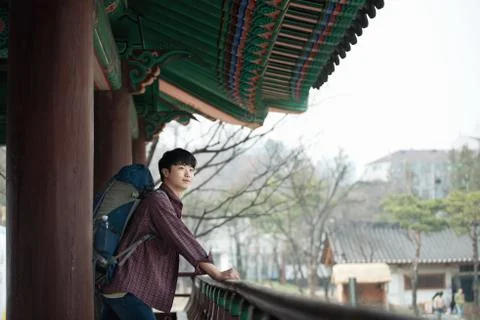 A young man doing a backpacking trip in a Korean traditional house. Stock Photos