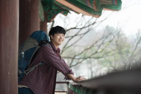 A young man doing a backpacking trip in a Korean traditional house. Stock Photos