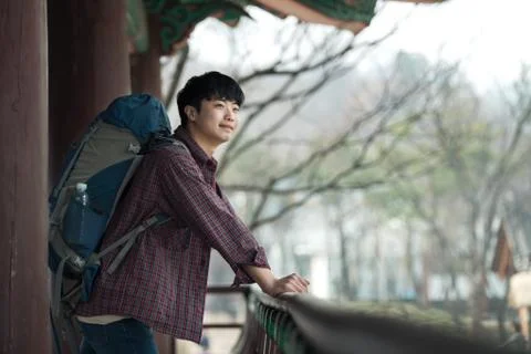A young man doing a backpacking trip in a Korean traditional house. Stock Photos