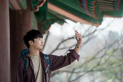 A young man doing a backpacking trip in a Korean traditional house. I'm takin Stock Photos