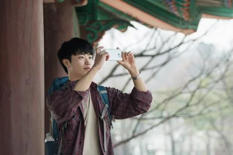 A young man doing a backpacking trip in a Korean traditional house. I'm takin Stock Photos