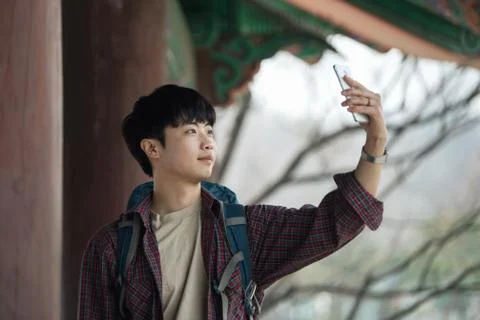 A young man doing a backpacking trip in a Korean traditional house. I'm takin Stock-Fotos