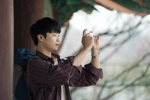 A young man doing a backpacking trip in a Korean traditional house. I'm takin Stock Photos