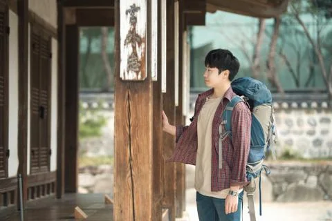 A young man doing a backpacking trip in a Korean traditional house. Stock Photos