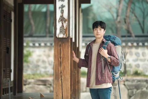 A young man doing a backpacking trip in a Korean traditional house. Stock Photos