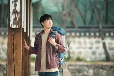 A young man doing a backpacking trip in a Korean traditional house. Stock Photos