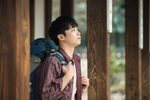 A young man doing a backpacking trip in a Korean traditional house. Stock Photos