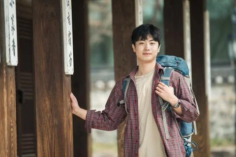 A young man doing a backpacking trip in a Korean traditional house. Stock Photos