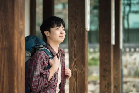 A young man doing a backpacking trip in a Korean traditional house. Stock Photos