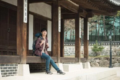 A young man doing a backpacking trip in a Korean traditional house. Stock Photos
