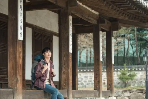 A young man doing a backpacking trip in a Korean traditional house. Stock Photos
