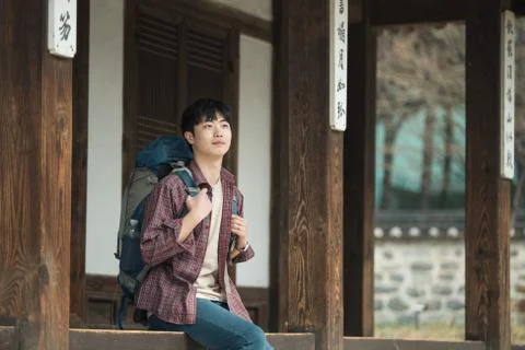 A young man doing a backpacking trip in a Korean traditional house. Stock Photos