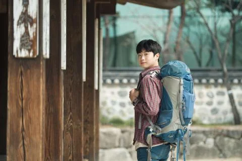 A young man doing a backpacking trip in a Korean traditional house. Stock Photos