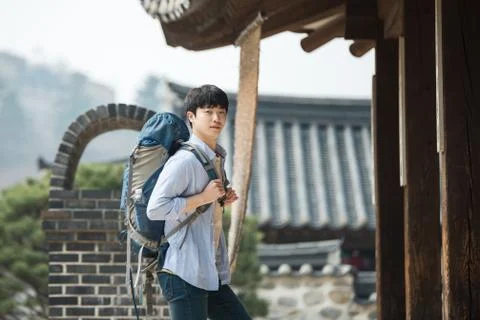 A young man doing a backpacking trip in a Korean traditional house. Stock Photos