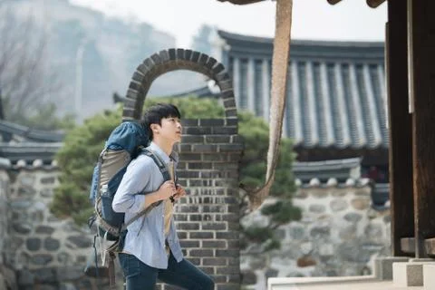 A young man doing a backpacking trip in a Korean traditional house. Stock Photos