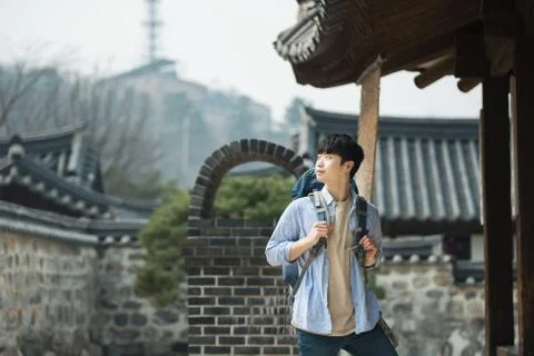A young man doing a backpacking trip in a Korean traditional house. Stock Photos