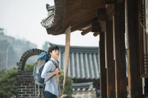 A young man doing a backpacking trip in a Korean traditional house. Stock Photos