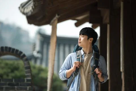 A young man doing a backpacking trip in a Korean traditional house. Stock Photos