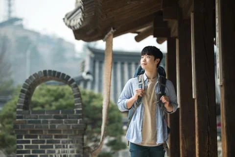 A young man doing a backpacking trip in a Korean traditional house. Stock Photos