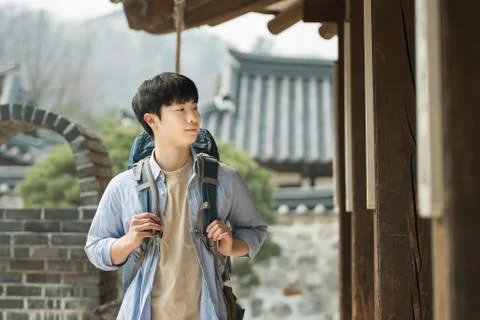 A young man doing a backpacking trip in a Korean traditional house. Stock Photos