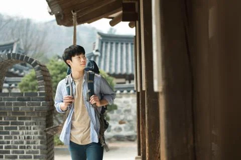 A young man doing a backpacking trip in a Korean traditional house. Stock Photos