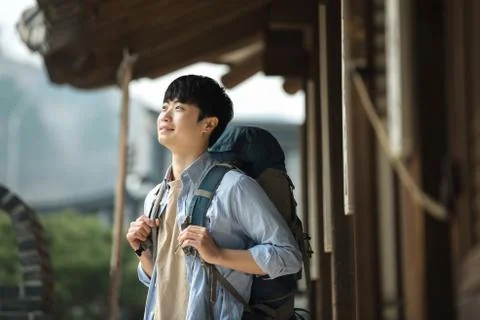 A young man doing a backpacking trip in a Korean traditional house. Stock Photos