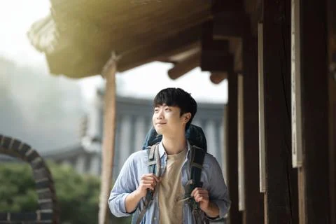 A young man doing a backpacking trip in a Korean traditional house. Stock Photos