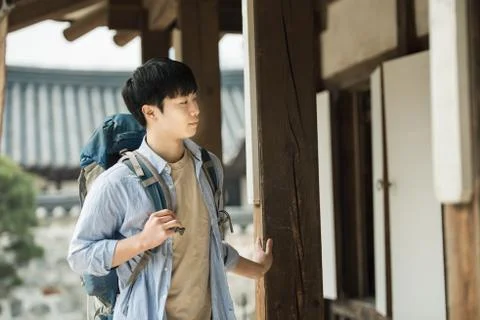A young man doing a backpacking trip in a Korean traditional house. Stock Photos