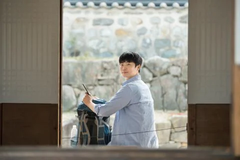 A young man doing a backpacking trip in a Korean traditional house. Stock Photos