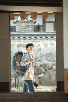 A young man doing a backpacking trip in a Korean traditional house. Stock Photos