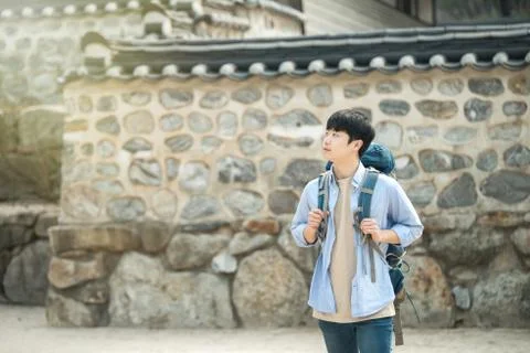 A young man doing a backpacking trip in a Korean traditional house. Stock Photos