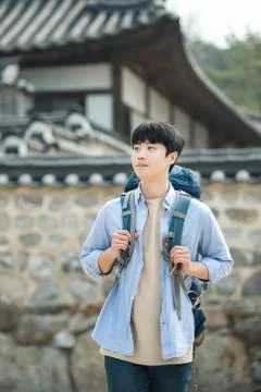 A young man doing a backpacking trip in a Korean traditional house. Stock Photos