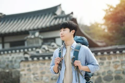 A young man doing a backpacking trip in a Korean traditional house. Stock Photos