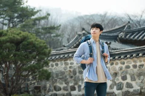 A young man doing a backpacking trip in a Korean traditional house. Stock Photos