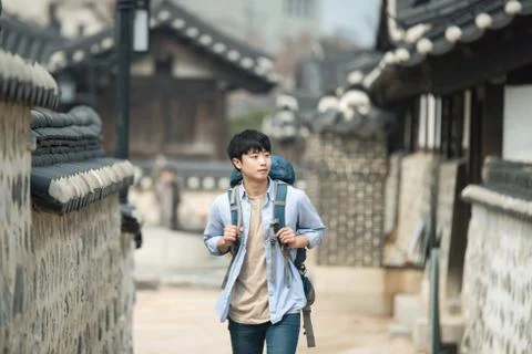 A young man doing a backpacking trip in a Korean traditional house. Stock Photos